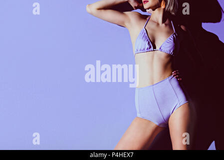 cropped view of stylish slim girl posing in purple bikini Stock Photo
