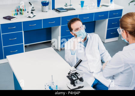 partial view of scientists having discussion at workplace in laboratory Stock Photo
