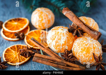 Mandarins, dried oranges, anise and cinnamon sticks on a wooden table Stock Photo