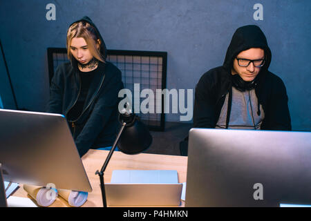 high angle view of thoughtful couple of hackers working on malware together Stock Photo