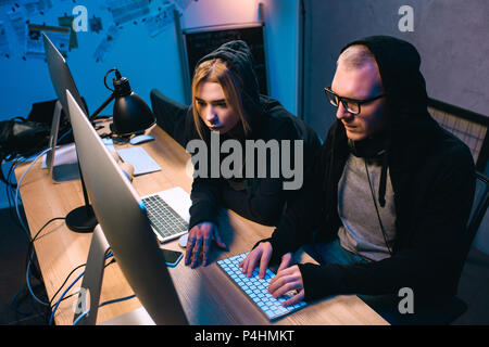 thoughtful couple of hackers working on malware together Stock Photo