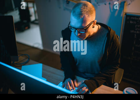 high angle view of hacker developing malware in dark room Stock Photo