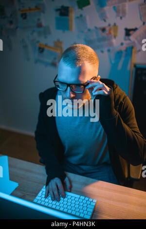 high angle view of serious hacker developing malware in dark room Stock Photo