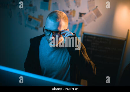 high angle view of young hacker developing malware in dark room Stock Photo