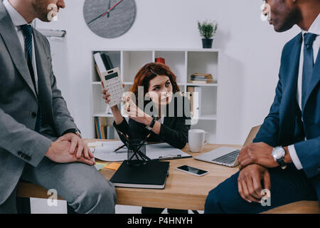 Investment adviser showing calculation to businessmen Stock Photo