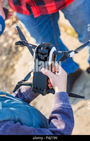male and children's hands holding drone and going to start a drone in the park. Preparing the launch of drone Stock Photo