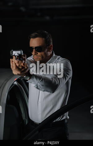 undercover male agent in sunglasses doing surveillance and using talkie  walkie in car Stock Photo - Alamy