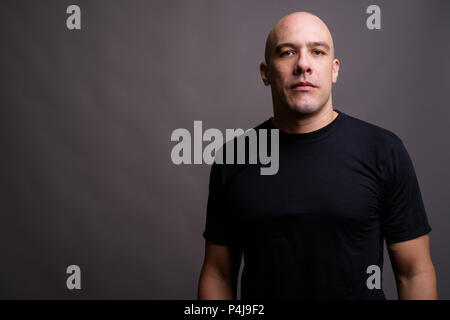 Handsome bald man against gray background Stock Photo