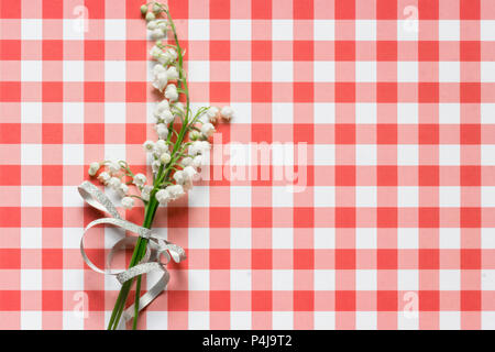 Lilly of valley on red and white checked pattern background Stock Photo