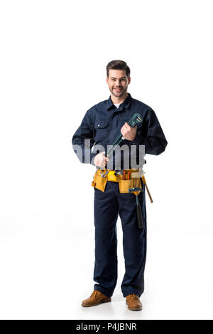 Confident handyman wearing uniform with tool belt and holding wrench isolated on white Stock Photo