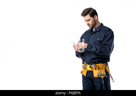 Professional plumber with tool belt using smartphone isolated on white Stock Photo