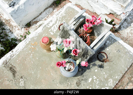 cemetary, tombestone and grave with plastic flowers. Latin America Stock Photo