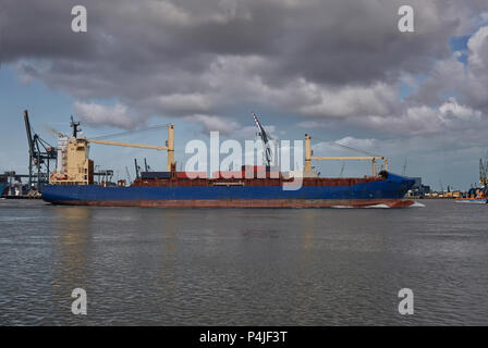 Panoramic image of a container ship passing cranes in Rotterdam harbor Stock Photo