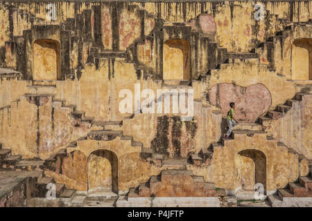 Local boy runs in the Step Well - Toorji Ka Jhalara. Local sight. Symmetry steps. Geometry. Heritage in Jodhpur, Rajasthan, India Stock Photo