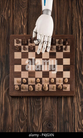 cropped shot of robot playing chess on wooden tabletop Stock Photo