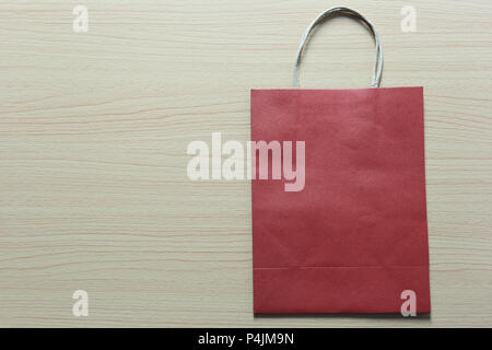 Red Paper bag is placed on a brown wooden floor and have copy space for design in your work. Stock Photo