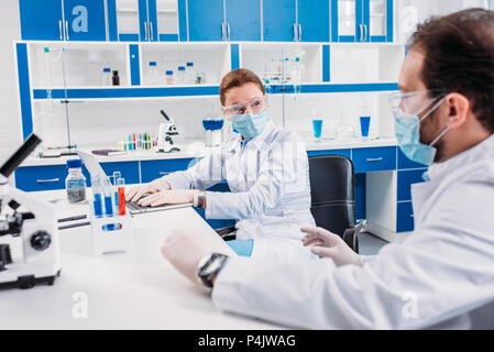 partial view of scientists having discussion at workplace in laboratory Stock Photo