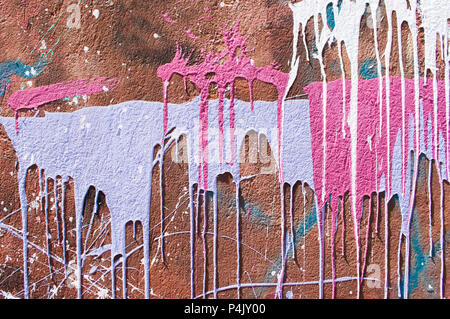 Paint drips om a red wall. Stock Photo