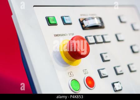 Red emergency stop button on control panel for stopping a machine in emergency situation Stock Photo