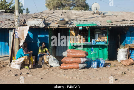 Addis Ababa, Ethiopia, January 30, 2014, People sitting outside small colorful grocery shops on a side street Stock Photo