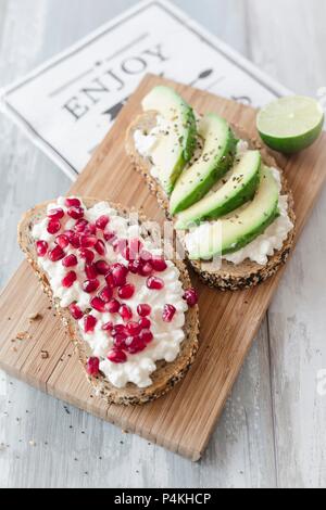 Seeded bread with cottage cheese, pomegranate seeds and avocado Stock Photo