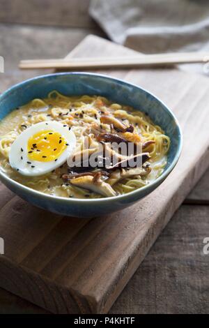 Asian food made with noodles, mushrooms, and vegetables on a black ...
