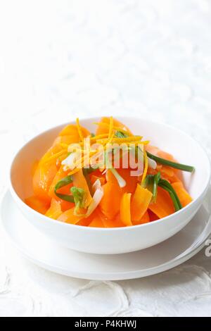A salad made from cooked carrots with oranges and spring onions
