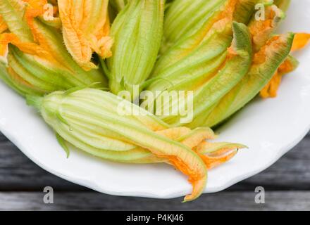 Several courgette flowers on a plate Stock Photo