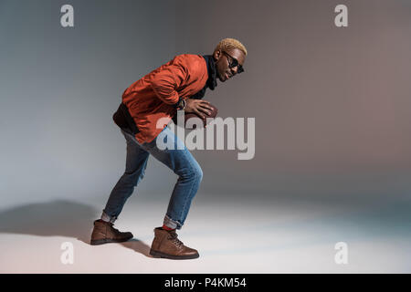 Stylish young african american man holding rugby ball preparing to run Stock Photo