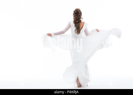 back view of elegant bride dancing in traditional wedding dress, isolated on white Stock Photo