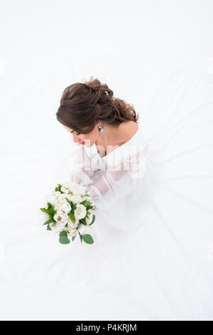 overhead view of elegant bride in traditional dress holding wedding bouquet, isolated on white Stock Photo