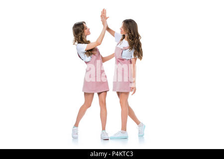 beautiful young twins giving high five isolated on white Stock Photo