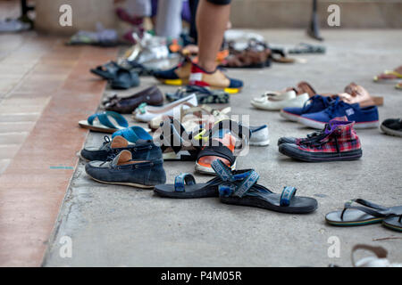 People take off their shoes on the steps in front of the entrance to a famous temple Stock Photo