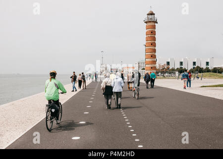 Lisbon, June 18, 2018: People stroll along the promenade in the Belem area. Some people ride bicycles. Ordinary city life Stock Photo