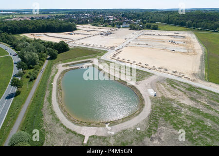 Aerial view from a rainwater basin and a new development area on sandy ground with the planum for new houses, taken at an angle, great height Stock Photo