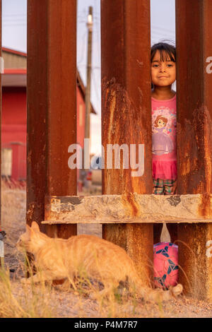 Children play on the Mexican side of the US Mexican border wall, Trump wall, Nogales, USA, Mexico. Stock Photo