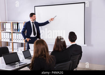 Young Businessman Giving Presentation To His Colleague In Meeting Stock Photo