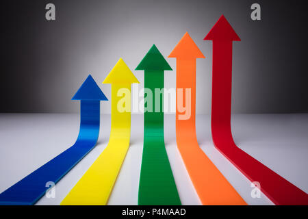 Colorful Arrows Pointing Upwards Against Gray Background Stock Photo