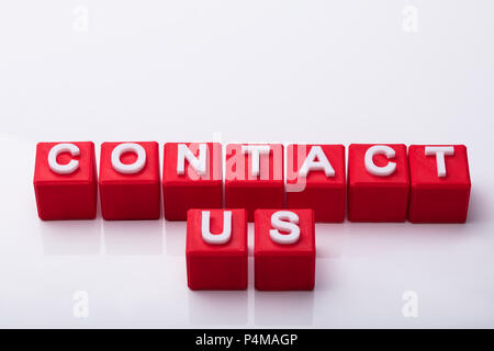 Elevated View Of Red Cubes With Contact Us Text On White Background Stock Photo