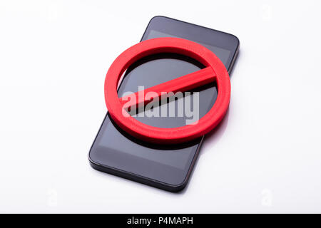 Elevated View Of Red No Sign On Mobile Phone Over White Background Stock Photo