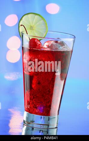 A red cocktail with ice cubes and cocktail cherries Stock Photo