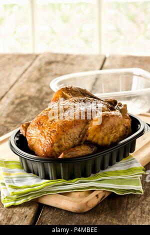 Rotisserie Chicken in Plastic Container with Lid Off Stock Photo