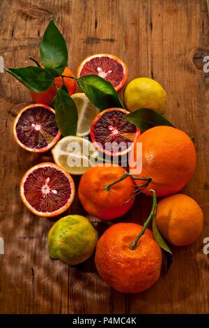 Blood oranges, mandarins and lemons on a wooden surface (seen from above) Stock Photo