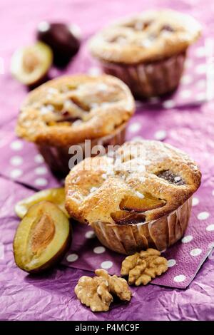 Plum and Walnut Muffins on purple background, selective focus Stock Photo