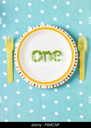 The word 'one' spelled out with peas on a plate Stock Photo