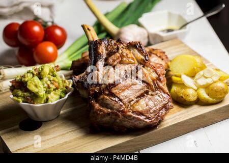 Veal cutlet with avocado salsa and garlic potatoes Stock Photo