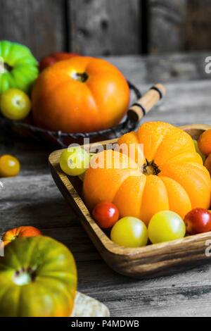 Colourful heirloom tomatoes on rustic wooden surface Stock Photo