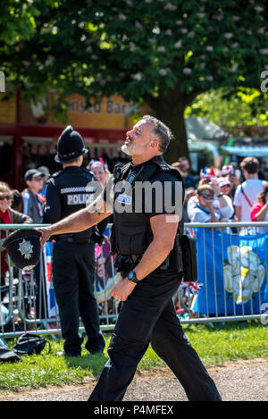 Sussex police officer Lee Willis entertains crowds on the Long Walk on the morning of the royal wedding of HRH Prince Harry and Ms. Meghan Markle by running up and down a stretch of the walk, encouraging crowds to cheer the loudest in a competition. He was seen removing police gear in order to continue running. The crowd seemed delighted during the entertainment. Stock Photo