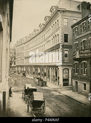 Antique circa 1860 photograph, Franklin Street looking east from Hawley Street, to Arch Street (on right) in Boston, Massachusetts. Old trade signs include Franklin Printing House; Alexander Moore Bookbinder; Burrage Brothers & Co.; Jewett Tebbetts & Co.; Allen Whiting & Co.; Dodge Baldwin & Co.; Austin Sumner & Co.; Denny Rice & Co. American Goods & Wool; B.C. Howard & Co.; Woodman Horswell & Co.; Wilkinson Stetson & Co.; J.W.H. Rogers & Co. House and Sign Painting. Most of the area was destroyed in the Great Boston fire of 1872. SOURCE: LATER GENERATION HIGH QUALITY PHOTOGRAPH Stock Photo