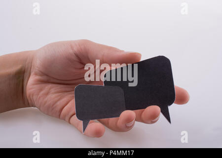 Hand holding dialogue boxes on a white background Stock Photo